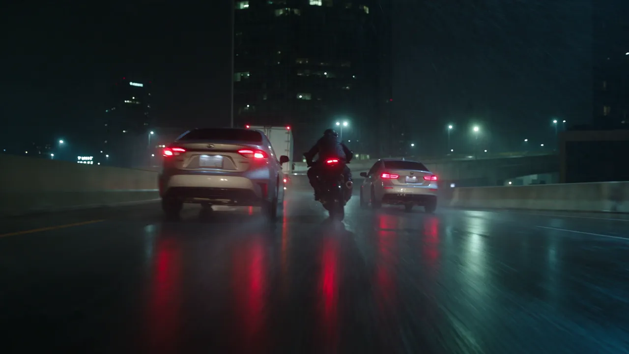 A courier on a black motorcycle weaves between cars on a rain-soaked elevated expressway at night, red tail lights smeared across the wet asphalt