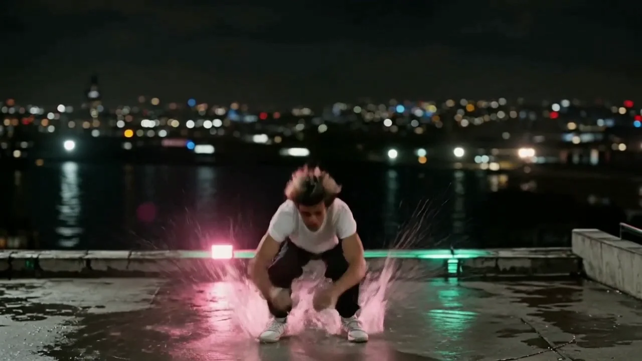 Kling v3: the same dancer and rooftop, a fast drive into a tight flip and a feet-first landing with a splash